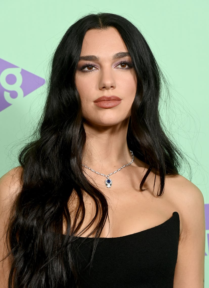 Dua Lipa with raven black hair, a a popular spring 2023 hair color trend, at the Capital Jingle Bell...