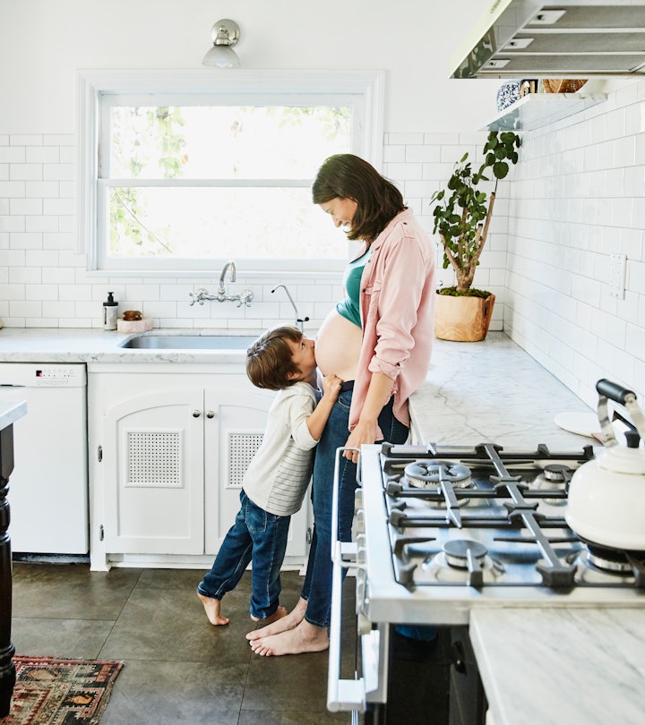 a mom and child in the kitchen with a gas stove. but are gas stoves dangerous do they cause asthma?