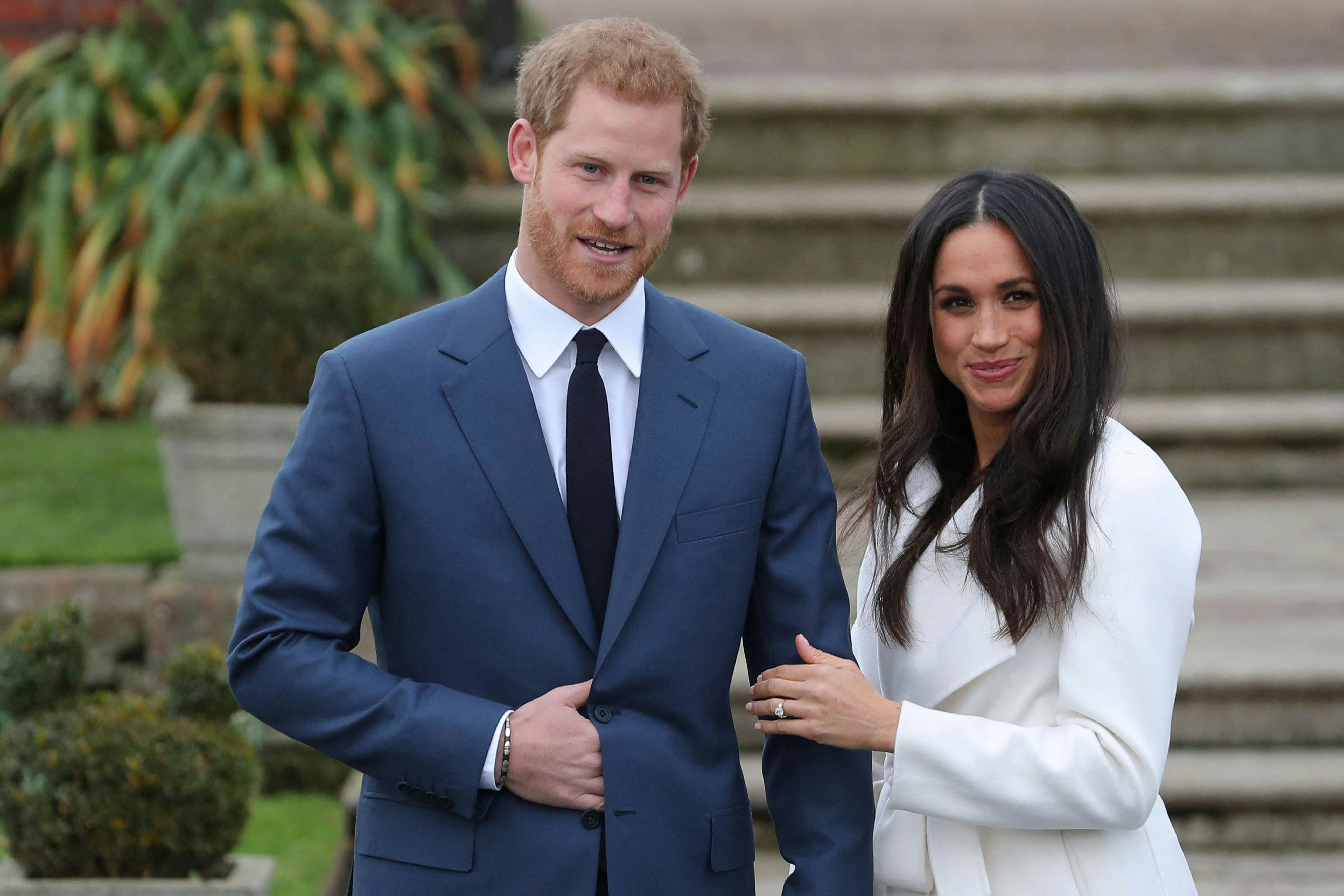 Britain&rsquo;s Prince Harry stands with his fiancée US actress Meghan Markle as she shows off her engagem&hellip;