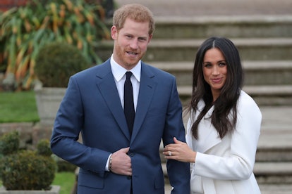 Britain's Prince Harry stands with his fiancée US actress Meghan Markle as she shows off her engagem...