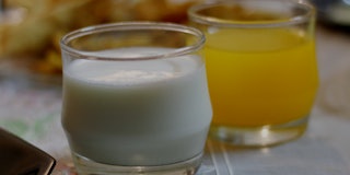 Glasses of milk and orange juice on table.