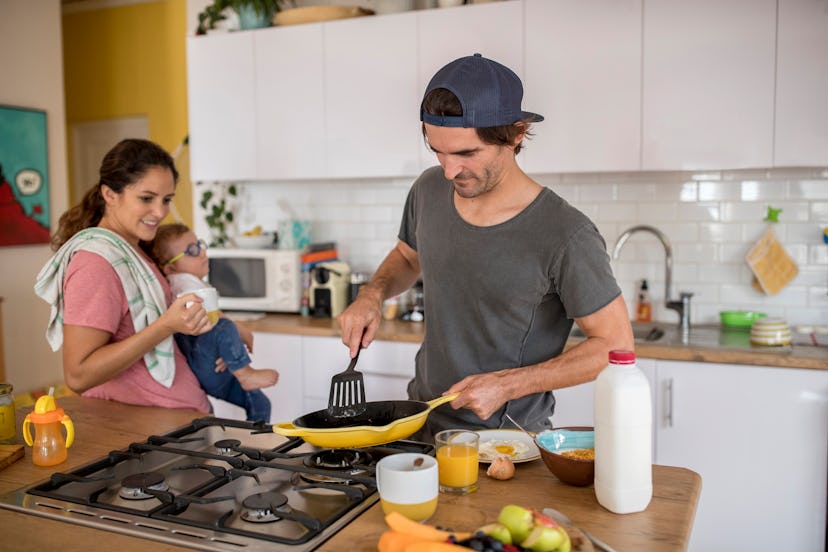 A man is preparing breakfast for family in an article about do gas stoves cause childhood asthma