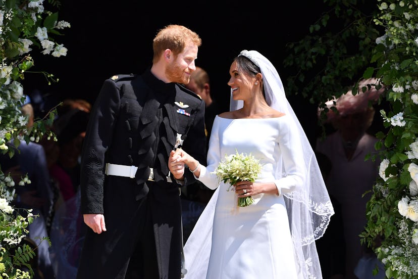 TOPSHOT - Britain’s Prince Harry, Duke of Sussex and his wife Meghan, Duchess of Sussex emerge from …