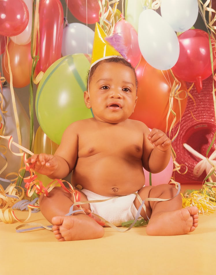 Baby in party hat with balloons