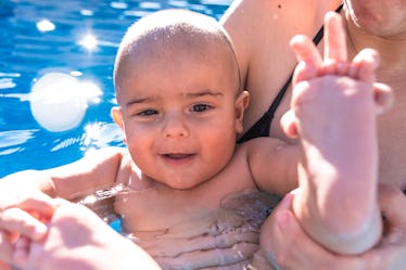 Portrait of a baby bathing in a swimming pool.