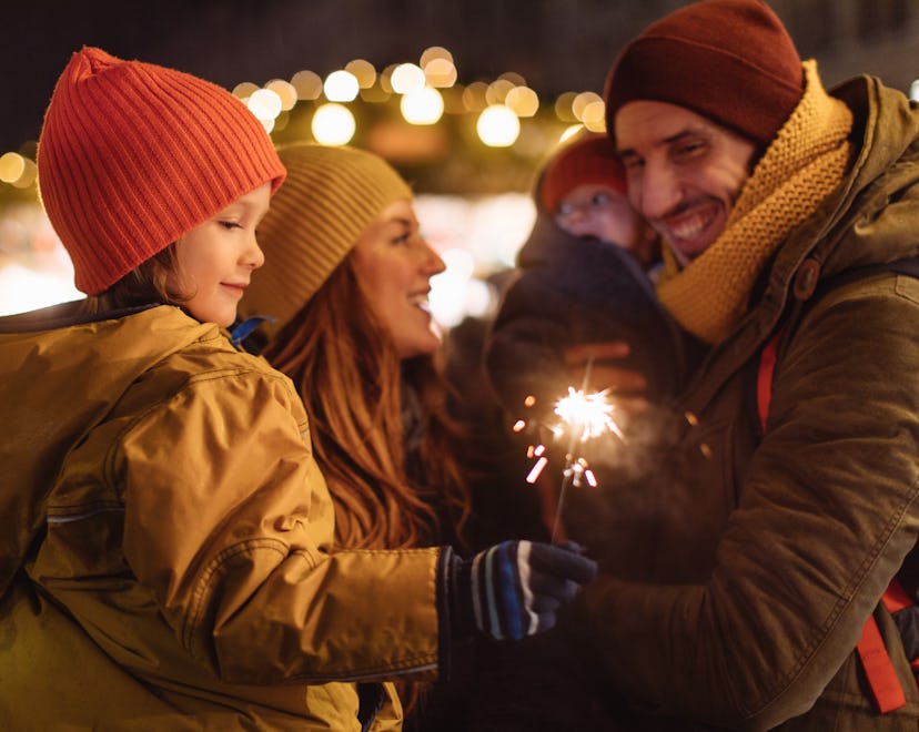 A family smiling and playing with sparklers, celebrating the Lunar New Year and Chinese Zodiac horos...