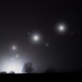 Glowing alien UFO lights floating in the sky. On a spooky foggy winters night