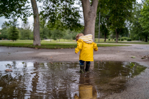 toddler boy splashing in puddle, illustrates the water-bearer aspect of baby names for aquarius