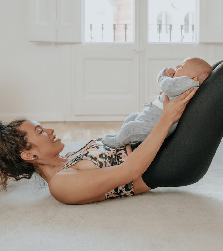 Mom exercises with baby at home, in a story about exercises to relieve postpartum back pain.