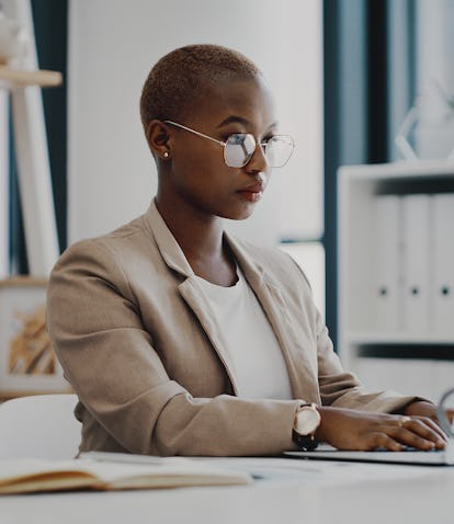 A young businesswoman with a Capricorn rising sign working on a laptop