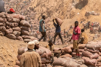 An artisanal miner carries a sack of ore at the Shabara artisanal mine near Kolwezi on October 12, 2019.