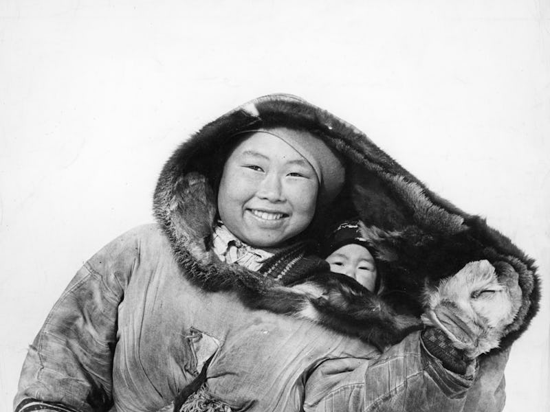 Femme esquimau portant son enfant dans le dos enveloppé dans une peau de caribou, en Alaska, Etats-U...