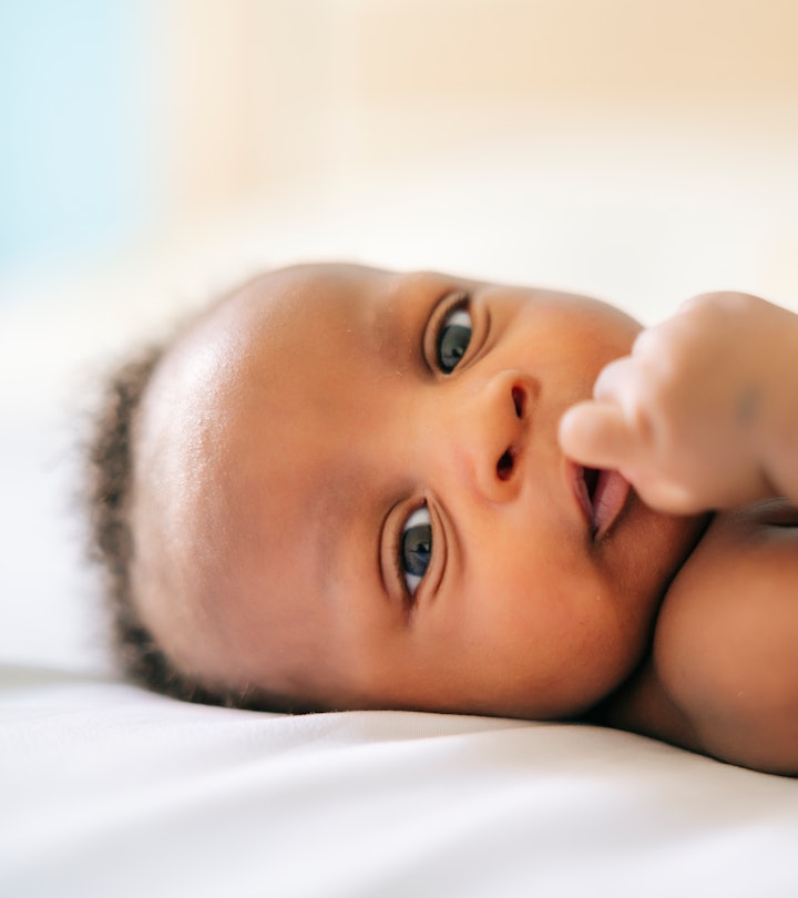 closeup of adorable black newborn baby laying on bed for article on baby girl names that start with ...