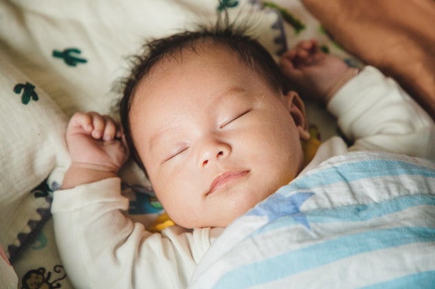 asian baby sleeping peacefully in a crib in article about baby boy names that start with Z