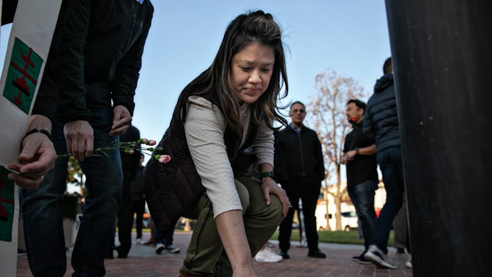 MONTEREY PARK, CA - JANUARY 22: A woman places flowers at a memorial where community members gathere...