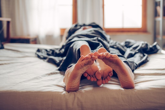 Adult couple's feet looking out of bed, vagina itchy after sex