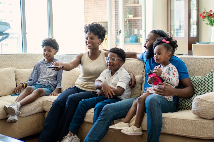 African American family watching tv at home