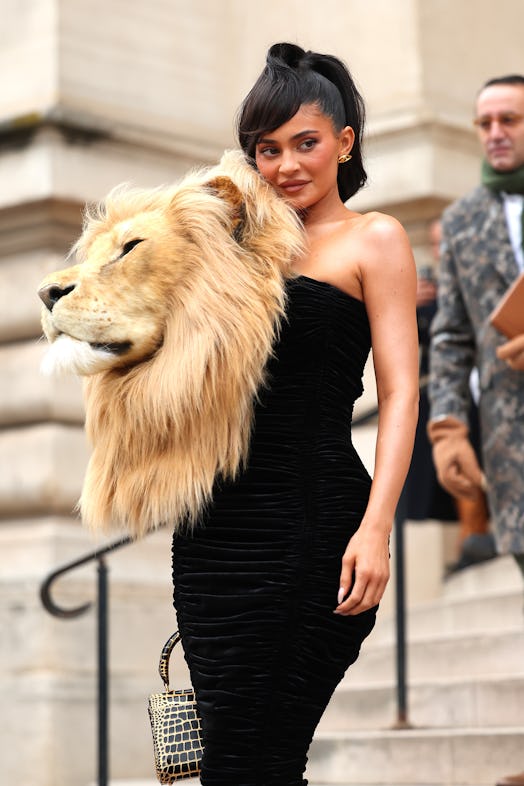 Kylie Jenner wore a ruched black gown adorned with a fake lion’s head to Schiaparelli's Haute Coutur...