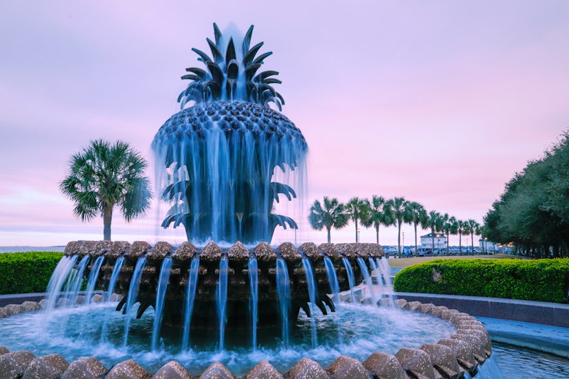 The iconic Pineapple Fountain surrounded by palmetto trees, Waterfront Park, Downtown Charleston, SC...