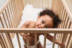 a cute toddler in crib, toddler keeps taking diaper off at night