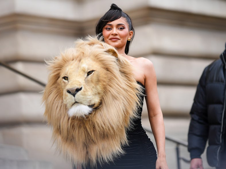 Kylie Jenner, a Leo, wears a dress with a large faux lion head during Paris Fashion Week