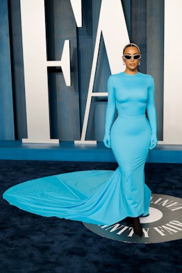 Kim Kardashian wearing a blue gown and sunglasses at the 2022 Vanity Fair Oscar Party