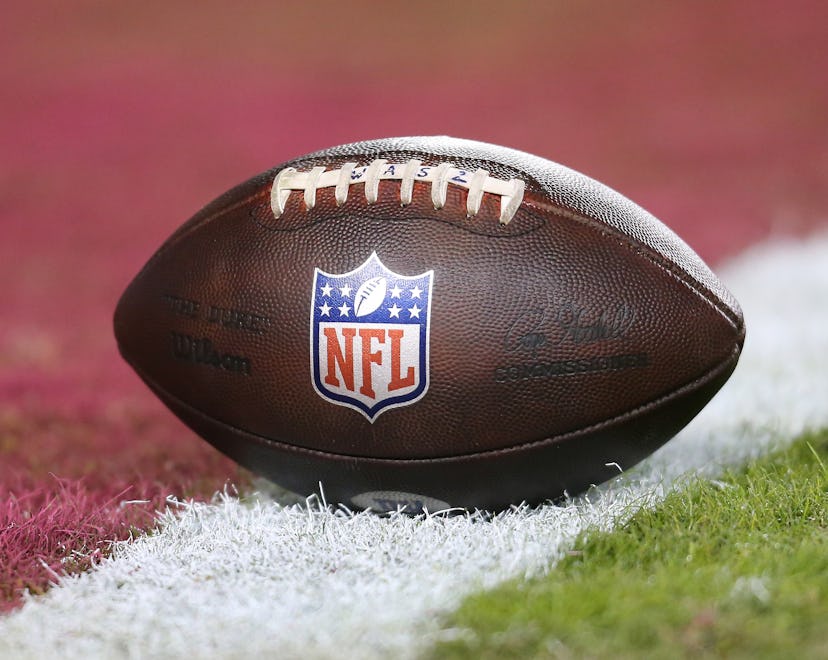 A football with the NFL logo on a football field in an article about how much the 2023 Super Bowl ri...