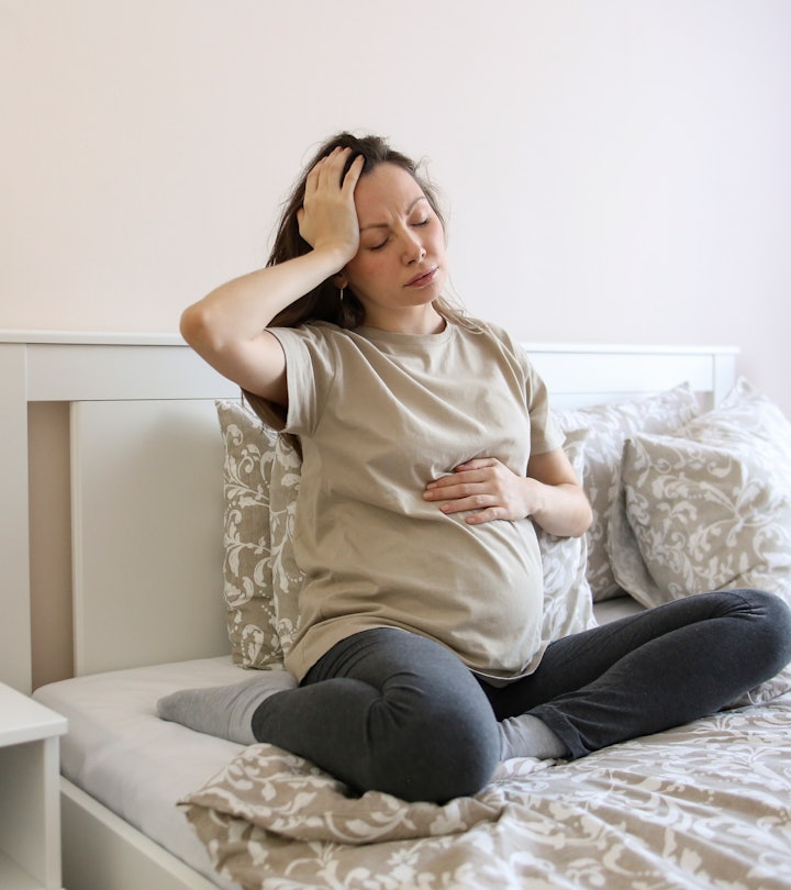 Pregnant woman looking nauseous in article about what foods fight nausea during pregnancy