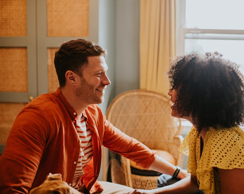 A couple looking at one another and smiling, expressing words of affirmation to show their love.