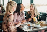 A front view shot of three beautiful mid-adult women enjoying brunch in article of galentine's day q...
