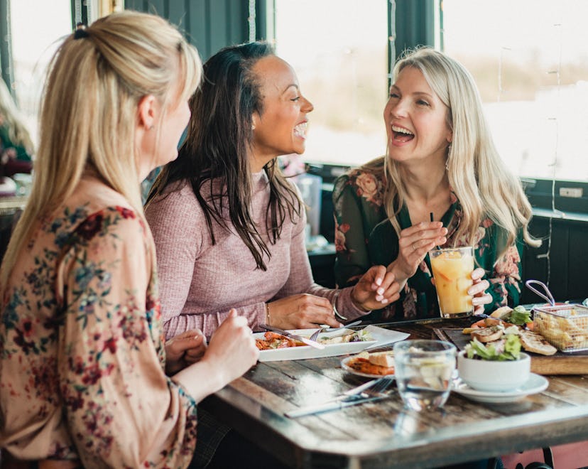 A front view shot of three beautiful mid-adult women enjoying brunch in article of galentine's day q...
