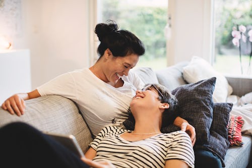 happy lesbian couple smiling at each other on couch in article about soul ties