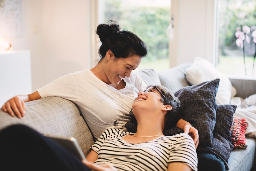 happy lesbian couple smiling at each other on couch in article about soul ties