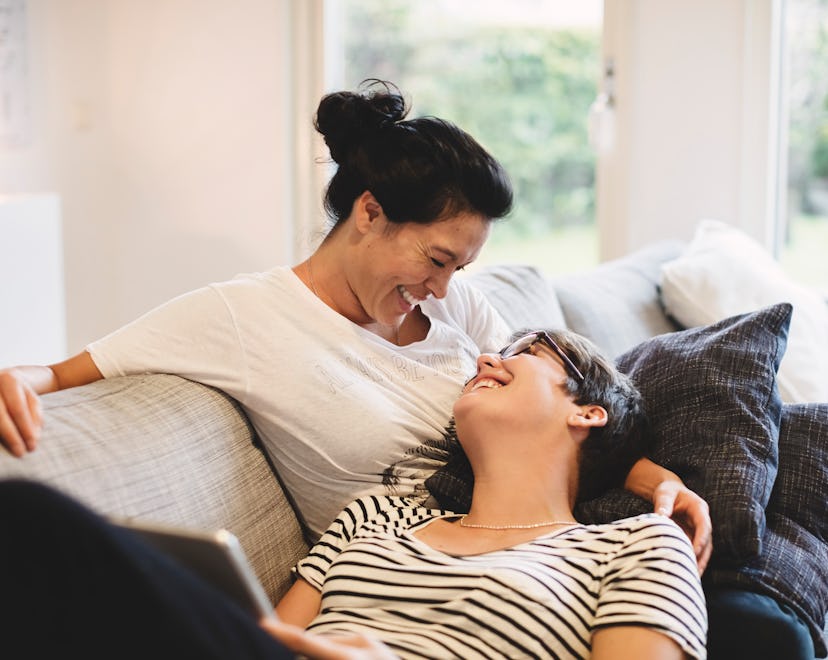 happy lesbian couple smiling at each other on couch in article about soul ties