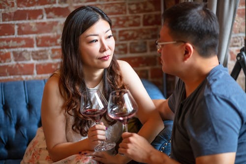 couple at restaurant drinking wine and asking relationship questions