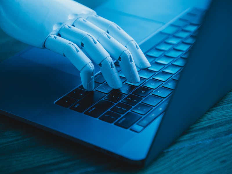 robotic hand using laptop (concept of AI replacing white collar worker)
