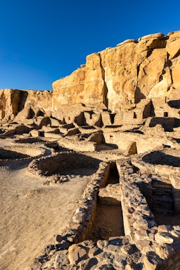 The largest of the great houses in Chaco Canyon, Pueblo Bonito is lit up by the late afternoon sun.