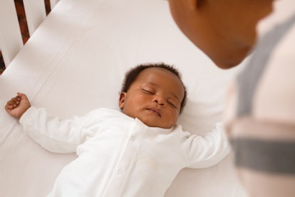 baby sleeping safely in a crib, in an article about why does my baby sleep better in my bed