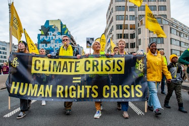 People are holding a banner from Amnesty International, during a massive climate demonstration organ...
