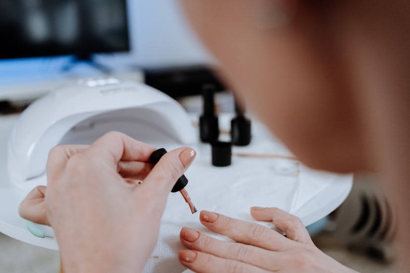 Woman painting her nails at home during pandemic