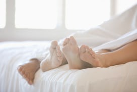 couple's feet tangled in sheets in article about dirty valentine's day puns