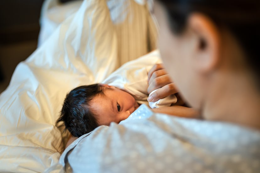 A photo of a mother breastfeeding newborn baby in the hospital, illustrating the idea to have the da...