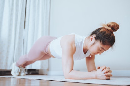 A woman does an easy Pilates workout at home for the 3-2-8 barre Pilates method. 