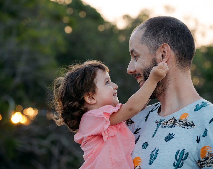 a dad and daughter playing, why does my toddler play with my ears