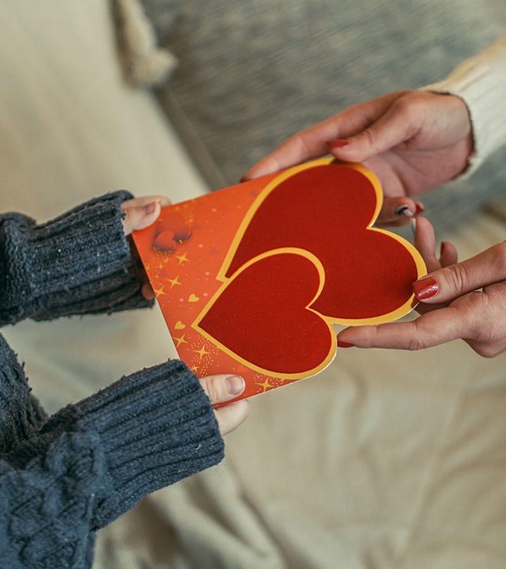 Mother hands child a card, after researching what to write in valentine's day card for child