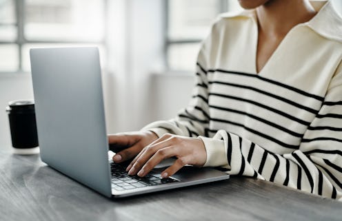 Laptop, hands typing and woman in home office writing report, email or social media content at desk....