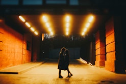 Couple kisses at night in a lit tunnel, and could potentially be in a karmic relationship