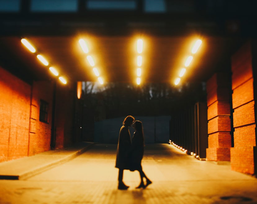 Couple kisses at night in a lit tunnel, and could potentially be in a karmic relationship