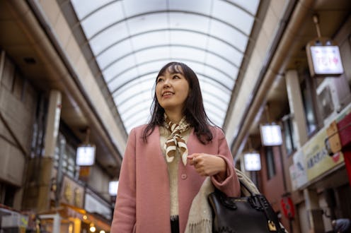 Young woman visiting shopping mall - low angle view