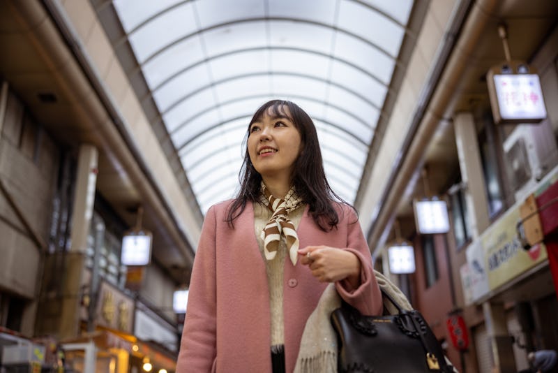 Young woman visiting shopping mall - low angle view